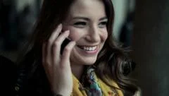 Beautiful woman talking on cellphone in city, steadicam shot HD