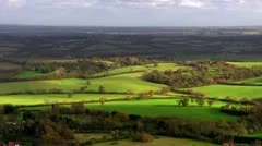Aerial shot over lush green fields and meadows in the English countryside