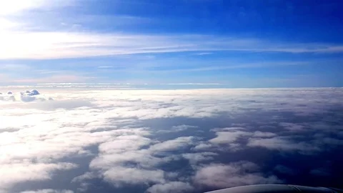 02 Blue sky with clouds. View through an airplane window. Flight over the ocean. Stock Footage 80927397