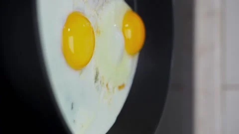02 two eggs are fried in a slow motion frying pan vertical Stock Footage 221127266