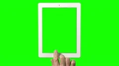 Hand in front of green screen operating a tablet