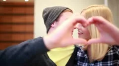 Couple kissing make heart-shape with hands