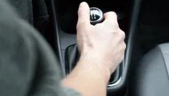 driving a car, with hand on the gearshift knob