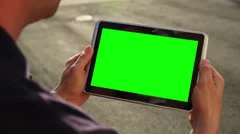 Man Holds Blank Green Screen Tablet PC Outside