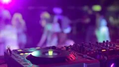 DJ hands and equipment during night club party with dancing people