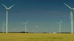 Driving by a windmill farm in a wheat field in the Midwest