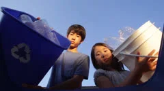 Asian Children Recycle Plastic Bottles by Throwing into a Bin - Slow Motion