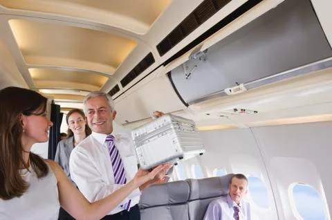 germany, bavaria, munich, passengers removing hand luggage from shelf in business class airplane cabin xkwx Vehicle Interior, transportation, color image, aeroplane, photography, Germany, Bavaria, Munich, indoor, day, vehicle seat, cabin, Travel, Business Trip, window, airplane window, people, caucasian appearance, four people, sitting, standing, smiling, happiness, toothy smile, togetherness, adults, man, senior men, Head and shoulders, mature adult, 40-50 years, 40-45 years, senior adults, 60-70 years, young adult, 20-30 years, holding, woman, mature woman, brown hair, 20-25 years, young women, 60-65 years, assistance, waist up, grey hair, Hand Luggage, Shirt and Tie, mature men, only adults, Preparation, shelf, business, business people, Businessman, Passenger, air travel, Business Class, flying, baggage, overhead locker, stowing