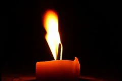 Shimmering light from burning candle at wind, open flame