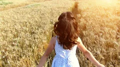 Little girl running cross the wheat field