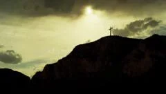 Christian Cross up on hill with Clouds and Sunbeams