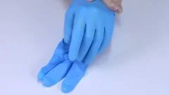 Woman hands putting on blue rubber gloves