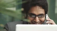 Shot of a businessman using a laptop while talking on mobile