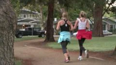 IN SHAPE GIRLS JOGGING IN NEIGHBORHOOD PARK FOR FITNESS HIGH DEFINITION HD 1080