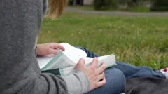 Girl reading bible outside (outdoors) on lap, dolly shot (devotions)