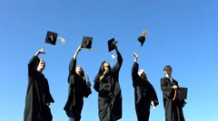 Group of graduates throwing graduation caps