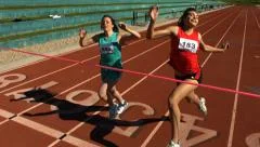 Track runner crosses finish line, slow motion
