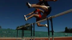 Athletes jump over hurdles, slow motion