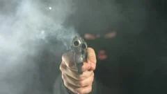Criminal shoots gun directly at camera, slow motion