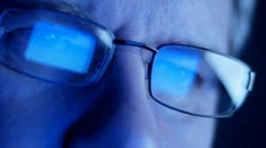 Computer screen and code reflected in man's glasses