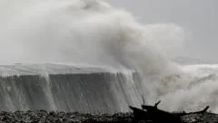 Storm waves crashing against sea defence/harbour wall