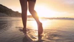 woman walking on beach barefoot sunset steadicam shot