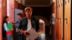 Depressed student walking to his locker and opening it