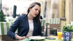 Businesswoman gets stomach ache during lunch in cafe HD