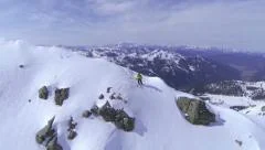 AERIAL: Extreme freeride skier skiing on top of the mountain