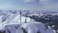 AERIAL: Backcountry skier standing on top of the mountain