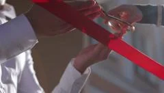 Cutting a red ribbon with scissors. Grand opening