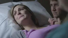 Pregnant Caucasian couple nervously watching ultrasound