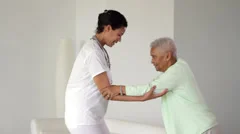 Nurse helping senior woman to walk