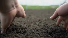 Point of view shot of two hands grabbing the soil and letting it to fall back