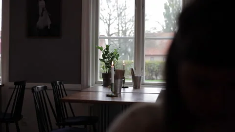 039 Romantic setting in restuarant by window with candles and wooden table in Stock Footage 130939060