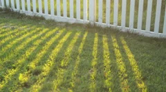 White picket fence casting shadow