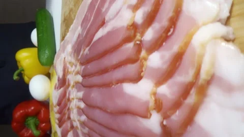 04 bacon strips fall on the cutting board vertical close up Stock Footage 221127104