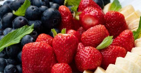 04.06.2022, auf dem Foto Erdbeeren, Blaubeeren und eien Banane in Scheiben... Stock Photos