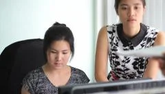 Asian Office Workers Going Over Numbers