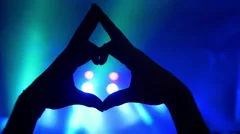 Hands forming heart at live music concert, festival