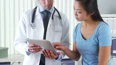 Hispanic doctor talking with patient with test results on tablet