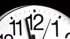 A white analog ticking clock shows the second and minute hands