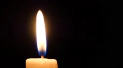 Close-up of a candle flame on black background. Loop.