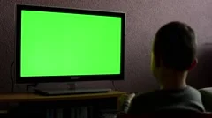 child (boy) watches television - child plays with a TV controller - green screen