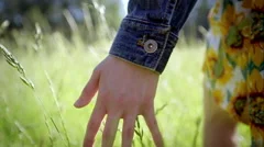 Close Up Of A Girl's Hand Feeling Tall Grass. Slow Motion. Lens Flare