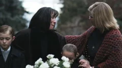 mother and children being consoled at a funeral