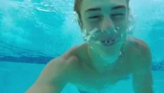 Teenage Boy Gets Running Start And Jumps Into Pool (Underwater GoPro Shot)