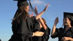 University students in academic caps and gowns celebrate their graduation