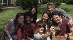 A group of racially-diverse students laugh for a selfie.