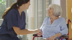 4K Caring nurse giving support to elderly female patient in care home